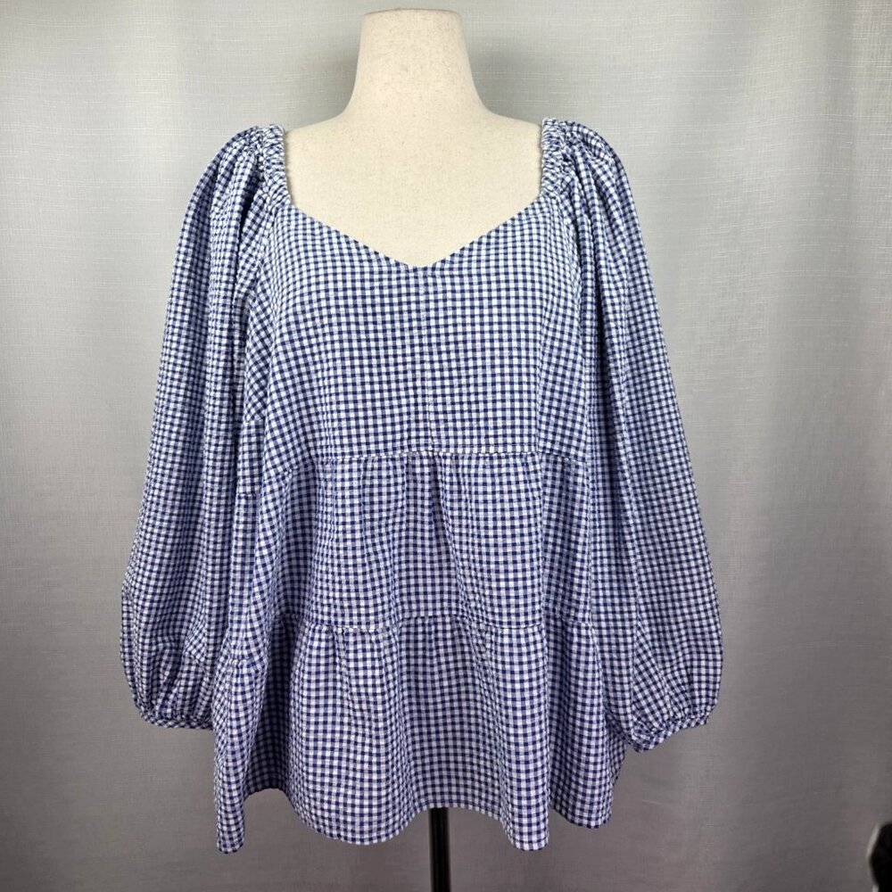 A blue long-sleeved top with countryside-style patterns all over it